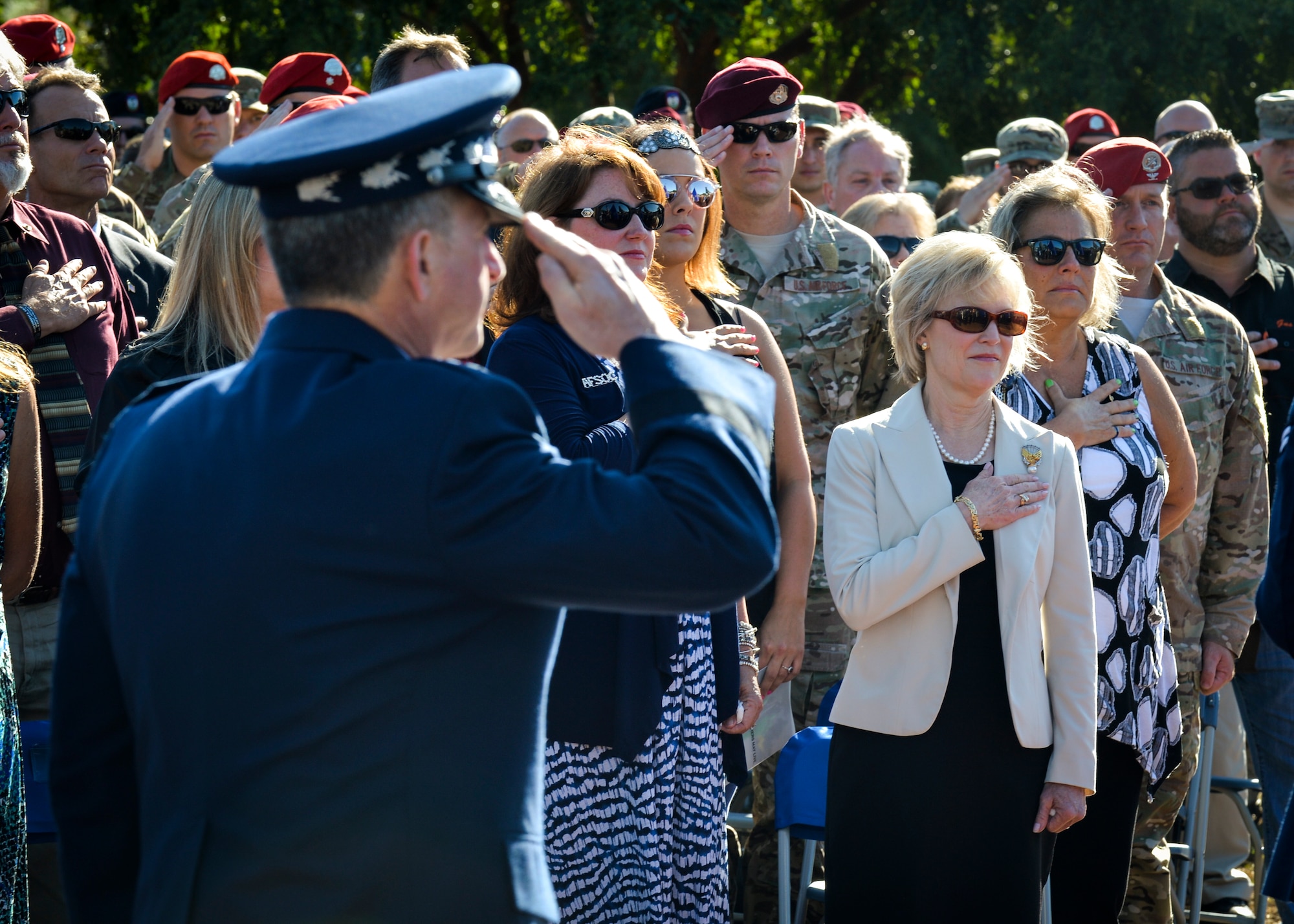Dawn Goldfein, wife of Air Force Chief of Staff David L. Goldfein, places her hand over her heart as the national anthem is performed during the Special Tactics Memorial dedication ceremony at Hurlburt Field, Fla., Oct. 20, 2016. During her visit, Dawn also met with AFSOC spouses, Airman and Family Readiness Center personnel, and received a Preservation of the Force and Family presentation. (U.S. Air Force photo by Senior Airman Andrea Posey)