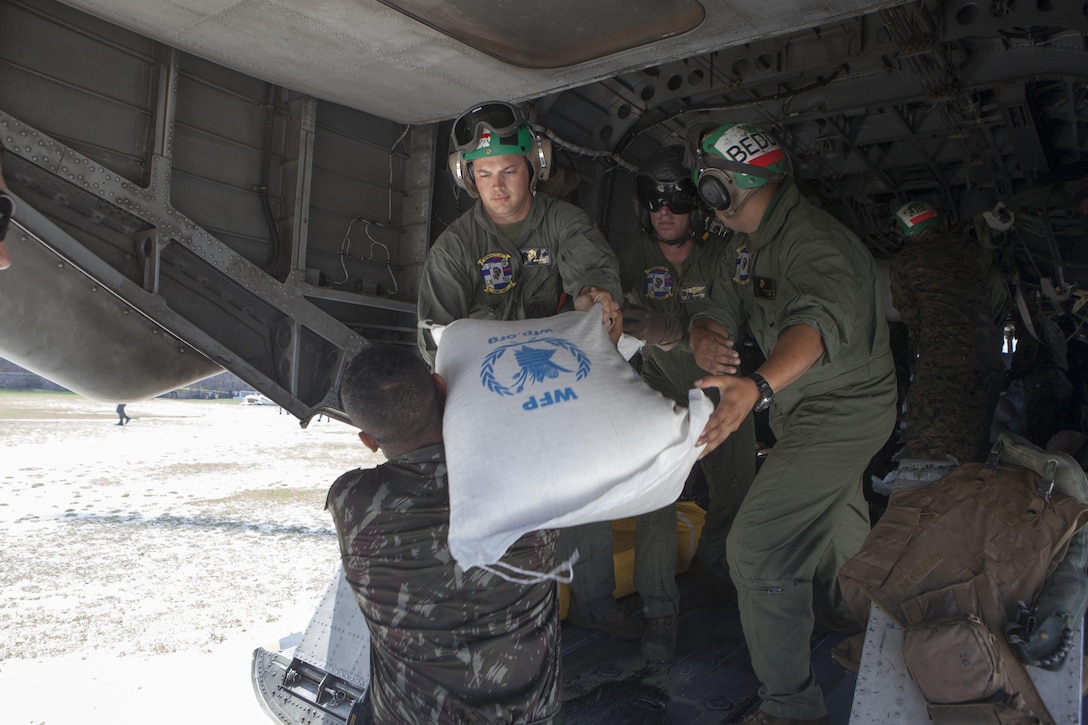 U.S. Marines with Special Purpose Marine Air-Ground Task Force-Southern Command deployed in support of Joint Task Force Matthew, deliver supplies with the help of the Brazilian military to locals affected by Hurricane Matthew at Jeremie, Haiti, Oct. 10, 2016. The supply drop operations of JTF Matthew delivered bags of rice, cooking oil and other supplies utilizing CH-53E Super Stallion and CH-47 Chinook helicopters. JTF Matthew, a U.S. Southern Command-directed team, is comprised of Marines with Special Purpose Marine Air-Ground Task Force – Southern Command and soldiers from Joint Task Force-Bravo’s 1st Battalion, 228th Aviation Regiment deployed to Port-au-Prince at the request of the Government of Haiti on a mission to provide humanitarian and disaster relief assistance in the aftermath of Hurricane Matthew.