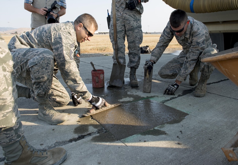 Airmen assigned to the 60th Air Mobility Wing complete a concrete taxiway repair at Travis Air Force Base, Calif., Aug. 19, 2016, 1st Expeditionary Civil Engineer Group airmen recently used similar techniques on a much larger scale to repair damage caused by Islamic State of Iraq and the Levant terrorists at Qayyarah West Airbase in northern Iraq’s Ninawa province. Air Force Photo by Heide Couch