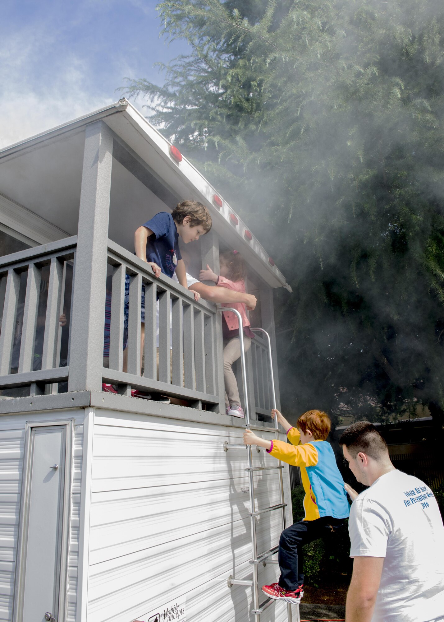 Yokota West Elementary School students escape a simulated fire during Fire Prevention Week on 12 Oct. 2016 at Yokota Air Base, Japan. Firefighters from the 374th Civil Engineer Squadron visited the elementary schools on base to demonstrate fire safety. (U.S. Air Force Photo by Airman 1st Class Donald Hudson/Released)