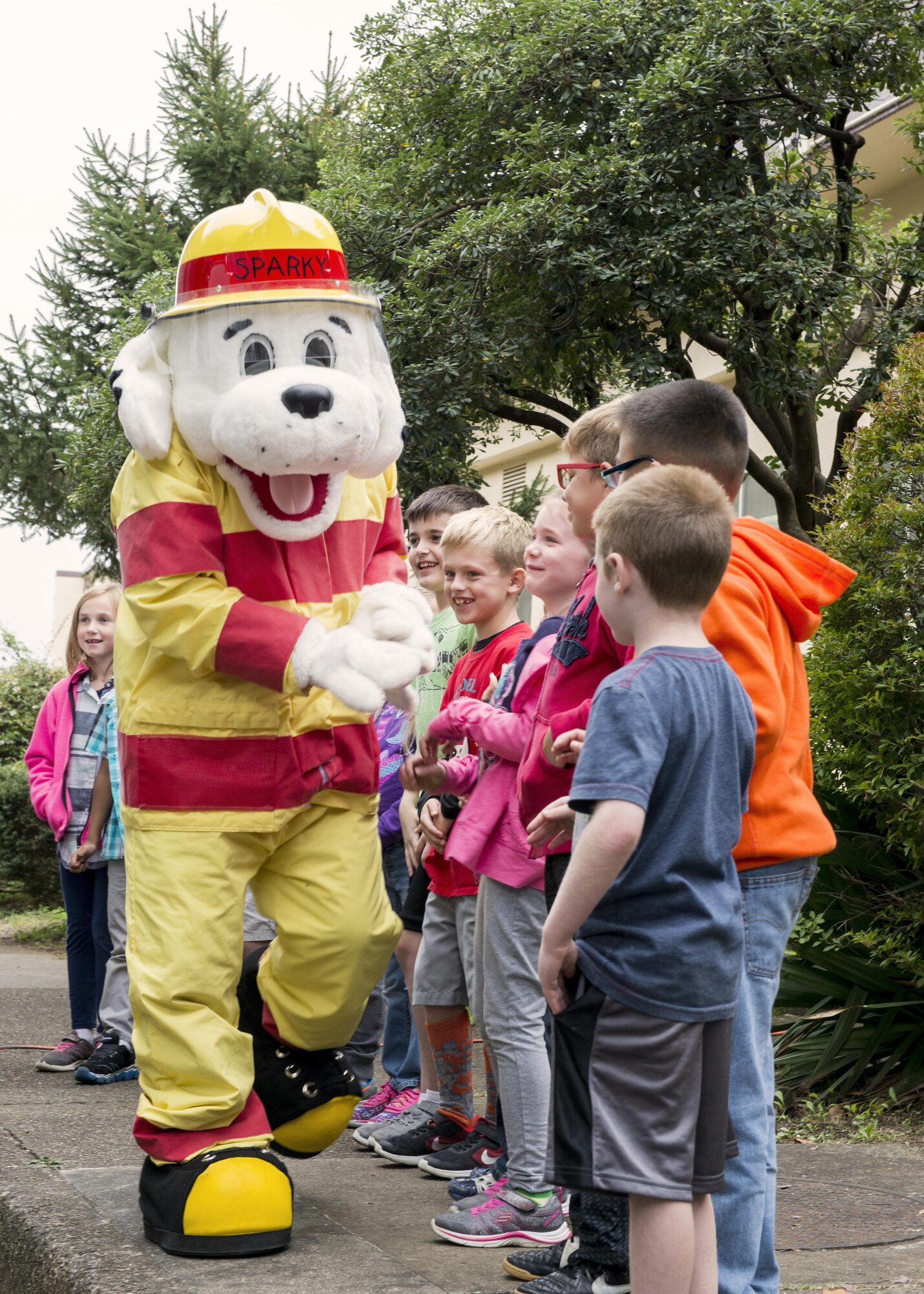 Students from Joan K. Mendel elementary get a high-five from Sparky the Fire Dog during Fire Prevention Week on 13 Oct. 2016 at Yokota Air Base, Japan. This year’s Fire Prevention Week theme is “Don’t Wait, Check the Date!” encouraging families to check their smoke alarms expiration date and batteries. (U.S. Air Force Photo by Airman 1st Class Donald Hudson/Released)