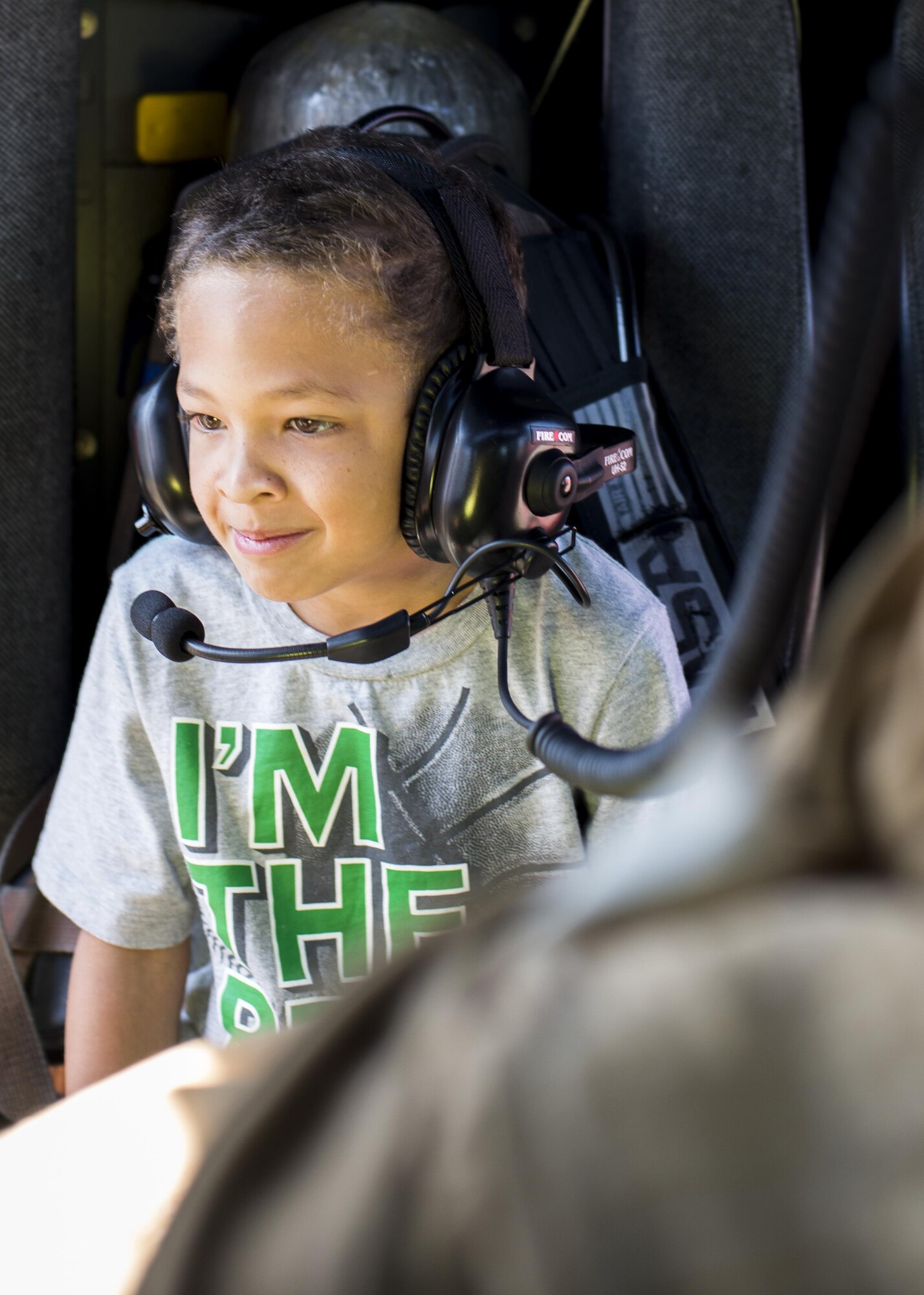 A child sits in a fire truck and tries on a head set at the Yokota Community Center during Fire Prevention Week on 15 Oct. 2016 at Yokota Air Base, Japan. Firefighters use Fire Prevention Week to promote fire safety and the importance of having a plan in case of a fire. (U.S. Air Force Photo by Airman 1st Class Donald Hudson/Released)