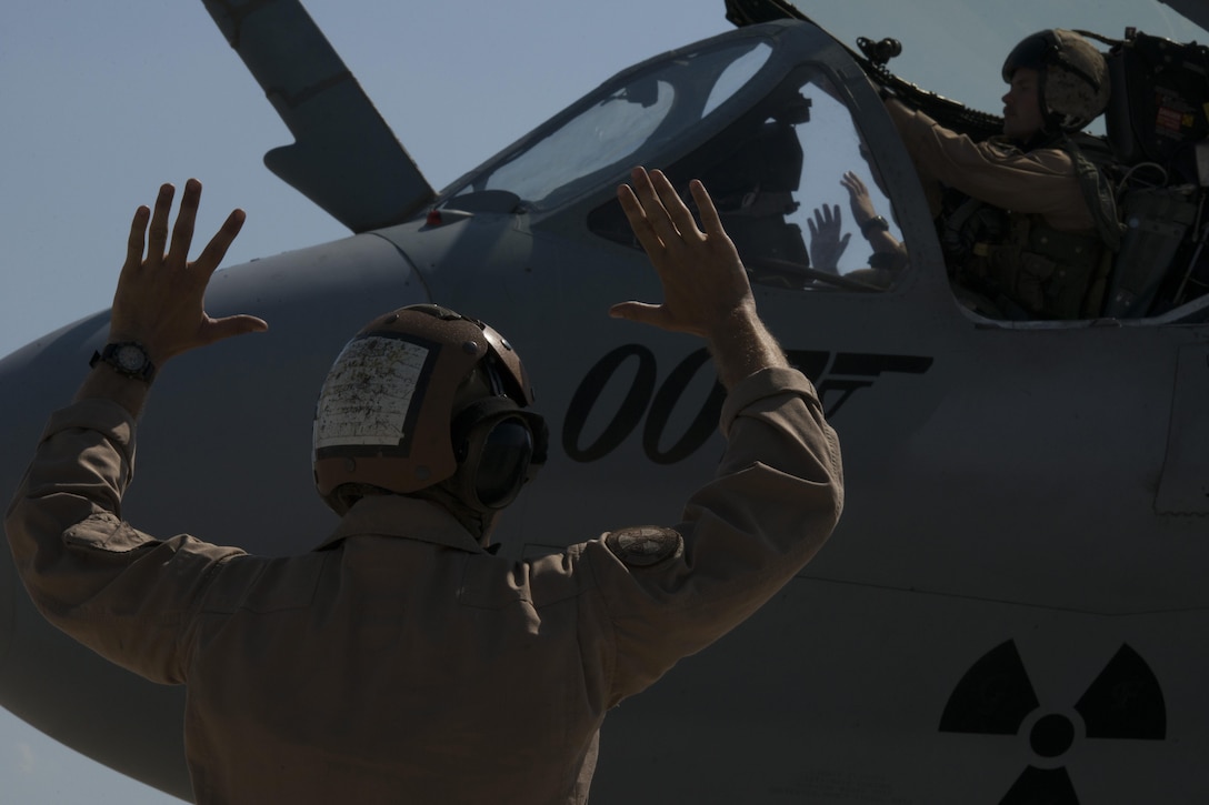 U.S. Marine Corps Cpl. Kogut Bradley, Tactical Electronic Warfare Squadron 4 plane captain, signals for hands up at Incirlik Air Base, Turkey, Sept. 16, 2016. Hands up is one of many hand signals used by plane captains and means ordnances are being armed. (U.S. Air Force photo by Staff Sgt. Ciara Gosier)