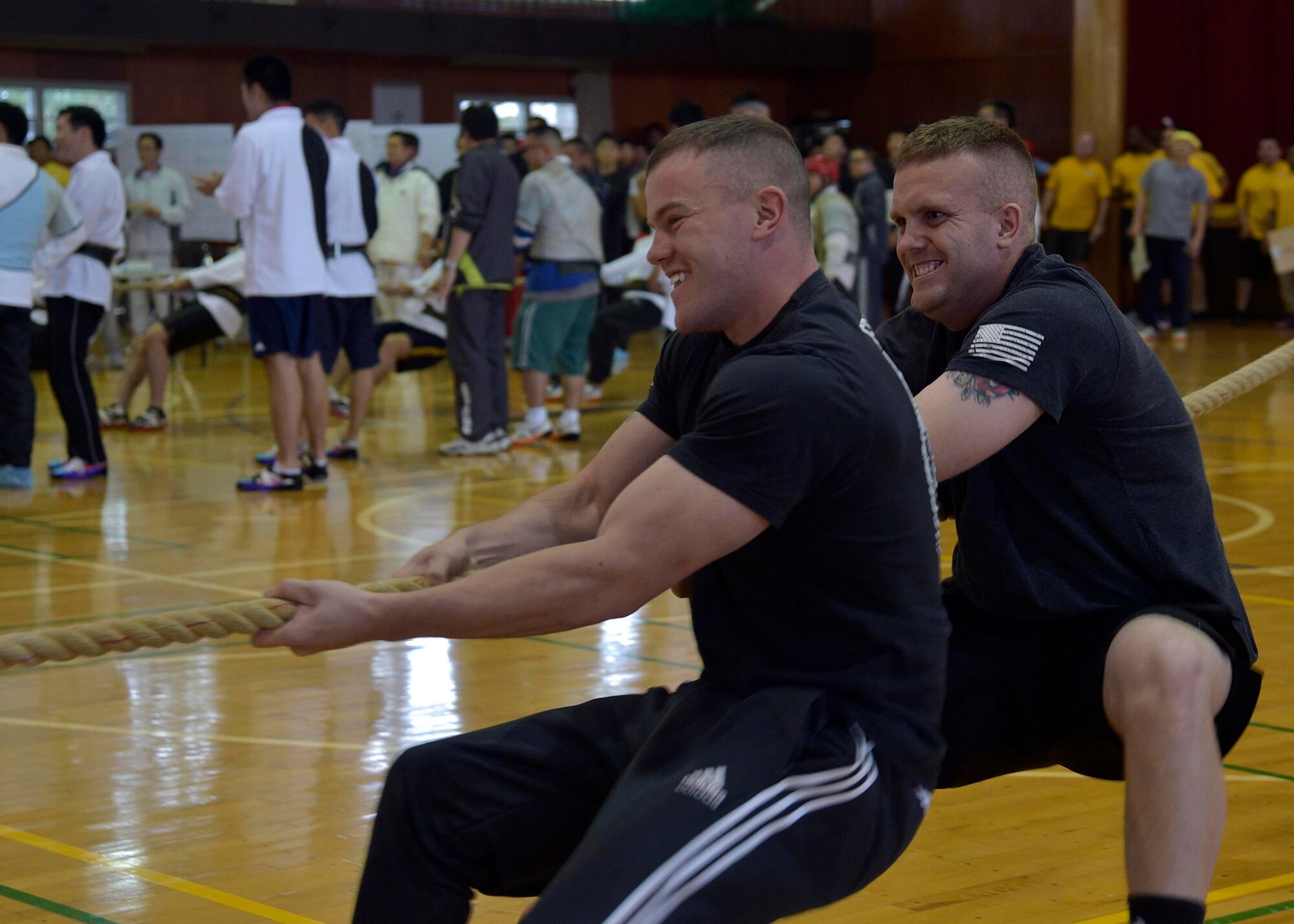 U.S. Air Force Senior Airman Dustin Kennedy, left, and Airman Harold Moore, right, both are 35th Maintenance Squadron aerospace propulsion members, pull a rope during the 15th Annual Northern Air Defense Force Commander’s Cup tug of war event at Misawa Air Base, Japan, Oct. 22, 2016. This annual event celebrates the strong bonds between U.S. and Japan Air Self-Defense Force military members and their families. (U.S. Air Force photo by Senior Airman Deana Heitzman)