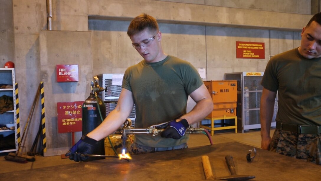Lance Cpl. Trevor Watson uses a welding tool to heat metal at General Support Maintenance Company on Camp Kinser, Okinawa, Japan, October 7, 2016. GSM repairs all secondary repairable items that cycle through III Marine Expeditionary Force. Because of the III MEF’s high operational tempo and the different environments they expose gear to, GSM is in high demand, according to Staff Sgt. Patrick Hubbard. Hubbard, a native of Albany, New York, is an ordinance chief and Watson, a native of Greeley, Colorado, is a welder with 3rd Maintenance Battalion, 3rd Marine Logistics Group, III Marine Expeditionary Force. (U.S. Marine Corps photo by Cpl. Natalie Dillon/Released) 