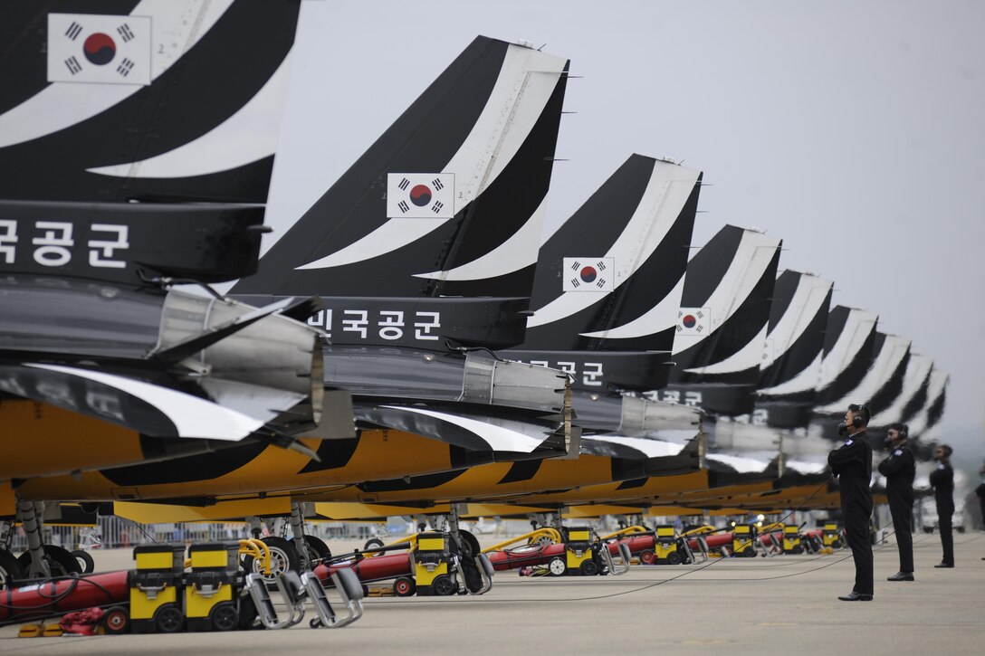 Crew chiefs for the Black Eagles demonstration team stand behind the T-50B aircraft as the pilots conduct their pre-flight checklist prior to a show at the Sacheon Airshow at Sacheon Base, Republic of Korea, Oct. 21, 2016. 7th Air Force provided both an F-16 and A-10 Thunderbolt II static display for the four-day airshow, showcasing U.S. Air Force capabilities to over 260,000 attendees. (U.S. Air Force photo by 1st Lt. Lauren Linscott/Released)