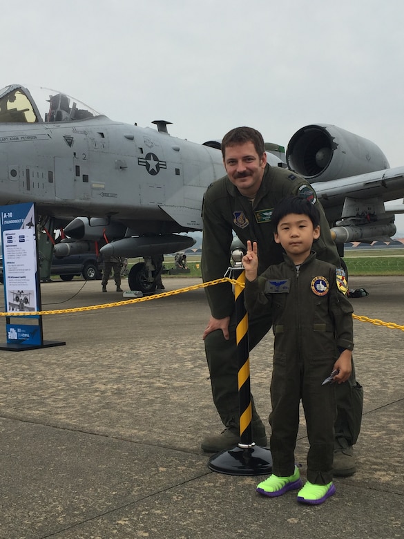 Capt. Daniel Hann, 25th Fighter Squadron pilot, poses with a Korean boy at the Sacheon Airshow at Sacheon Base, Republic of Korea, Oct. 20, 2016. 7th Air Force provided both an F-16 and A-10 Thunderbolt II static display for the four-day airshow, showcasing U.S. Air Force capabilities to over 260,000 attendees. (U.S. Air Force photo by 1st Lt. Lauren Linscott/Released)