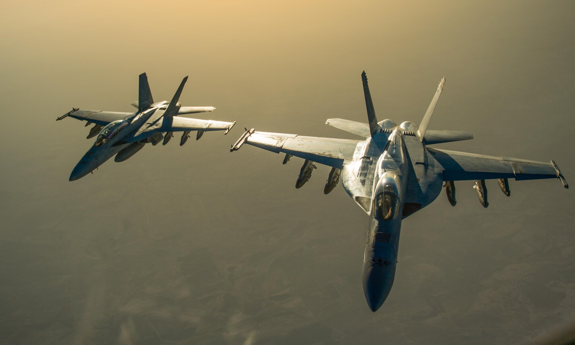 Two U.S. Navy F/A-18 Super Hornets fly in formation after receiving fuel from a KC-135 Stratotanker over Iraq in support of Operation Inherent Resolve Oct 17, 2016. The operational mission of Operation Inherent Resolve is to militarily defeat Da'esh in the Combined Joint Operation Area in order to enable whole-of-coalition governmental actions to increase regional stability.(U.S. Air Force photo by Staff Sgt. Douglas Ellis/Released)