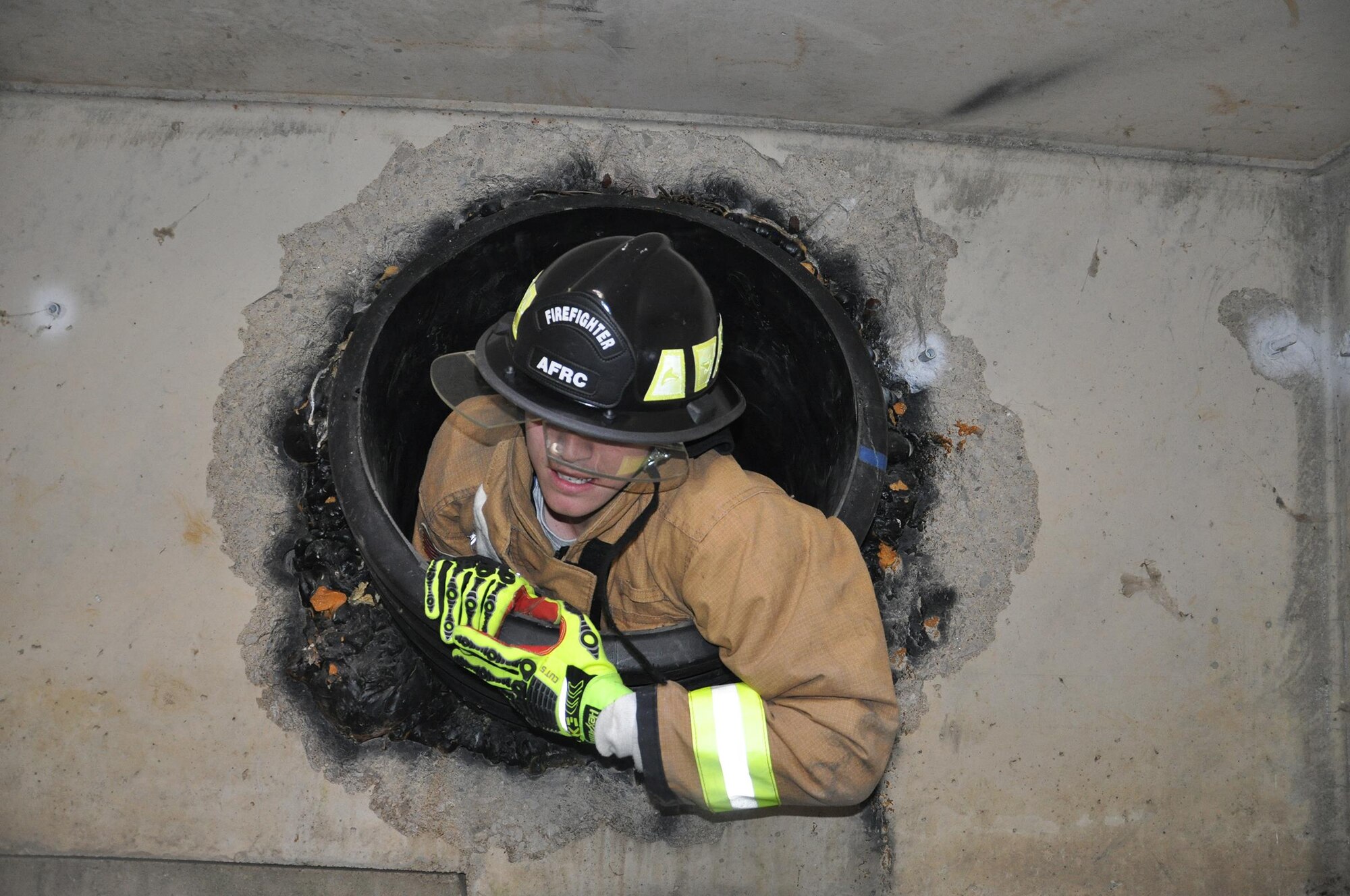 Senior Airmen Greg Osborne, 445th Civil Engineer Squadron fire protection journeyman, crawls through down a hole to rescue a simulated injured child during a confined space training exercise Oct. 8, 2016. (Courtesy photo)