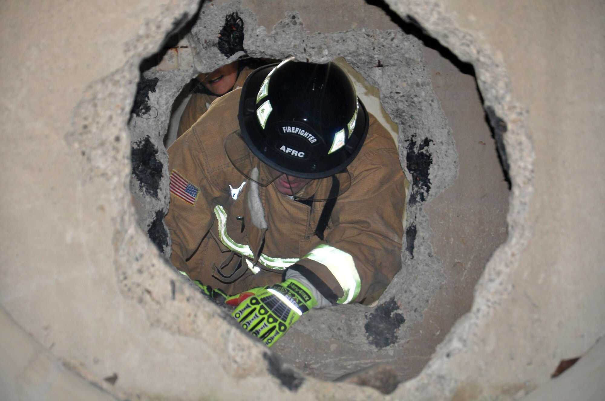 Senior Airmen Greg Osborne (in front) and Alexandria Lopez, 445th Civil Engineer Squadron firefighters, crawl through debris to rescue a simulated injured child during a confined space training exercise Oct. 8, 2016. The training was conducted on base near Bass Lake at the Fire Departments training simulators. (Courtesy photo)