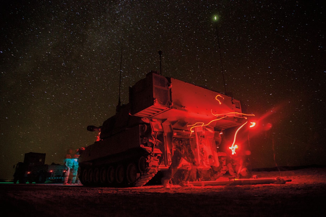 Soldiers assigned to Bravo Company, 1st Battalion, 77th Armor Regiment, 4th Armored Brigade Combat Team, 1st Armored Division, provide security with a M109A6 Paladin prior to reconnaissance patrol during Decisive Action Rotation 14-10 at National Training Center at Fort Irwin, California, September 24, 2014 (U.S. Army/Richard W. Jones, Jr.)