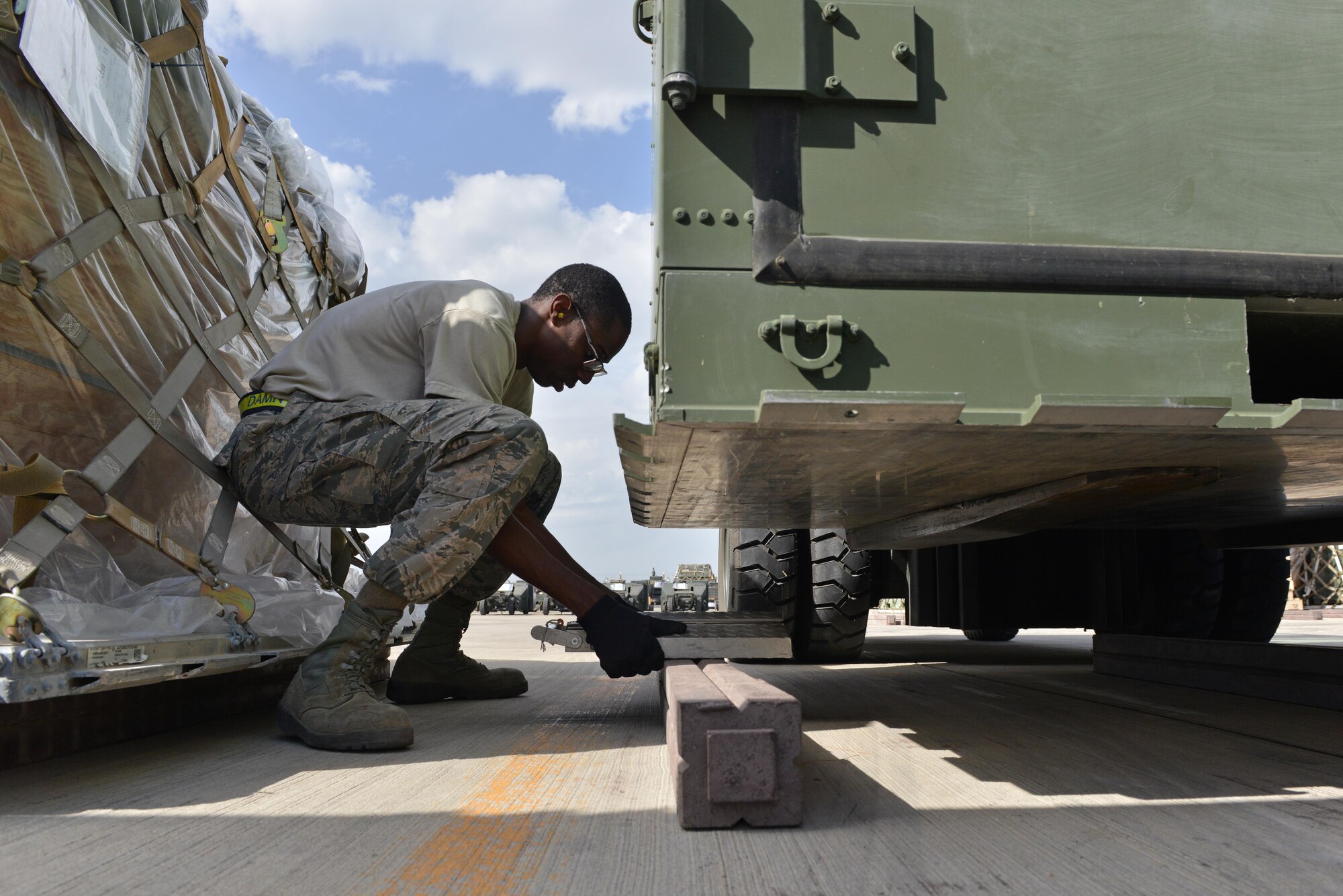 U.S. Air Force Airman 1st Class Josiah Purnell, 728th Air Mobility Squadron air transportation journeyman, places a scale underneath cargo Oct. 18, 2016, at Incirlik Air Base, Turkey. While inspecting cargo, air transportation specialists validate cargo weight and document accordingly. (U.S. Air Force photo by Senior Airman John Nieves Camacho)