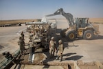 A U.S. Airman pours dry concrete into a volumetric mixer during runway repair operations at Qayyarah West airfield, Iraq, Oct. 9, 2016. The 1st Expeditionary Civil Engineering Group has been tasked to repair the runway after The Islamic State of Iraq and the Levant (ISIL) destroyed it to disrupt Coalition forces from gaining control in the area. A Coalition of regional and international nations have joined together to enable Iraqi forces to counter ISIL, reestablish Iraq’s borders and re-take lost terrain thereby restoring regional stability and security.  (U.S. Army photo by Spc. Christopher Brecht)