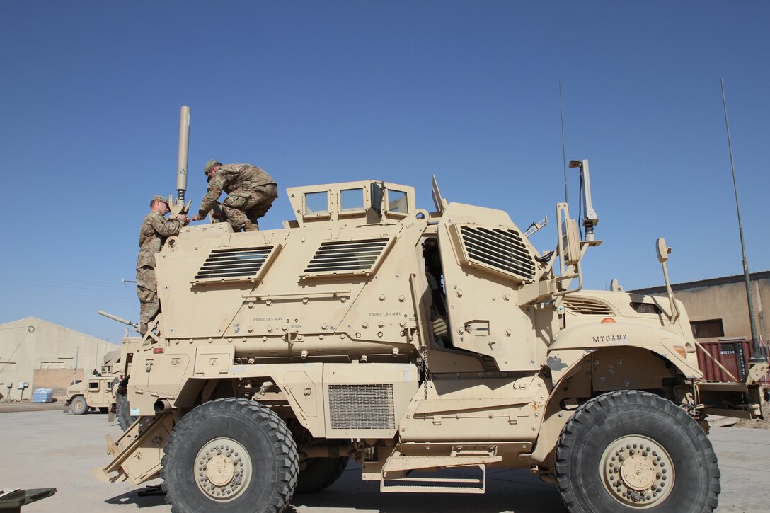 Army Reserve Sgt. Charles Smalley and Sgt. Alex Katz, both signal support systems noncommissioned officers with the 451st Expeditionary Sustainment Command, install a Blue Force Tracker system on a tactical vehicle for the 300th Sustainment Brigade Det. 2, Sept. 20, 2016 at an undisclosed location in Iraq. (Army Photo by Spc. Milagro Perez)