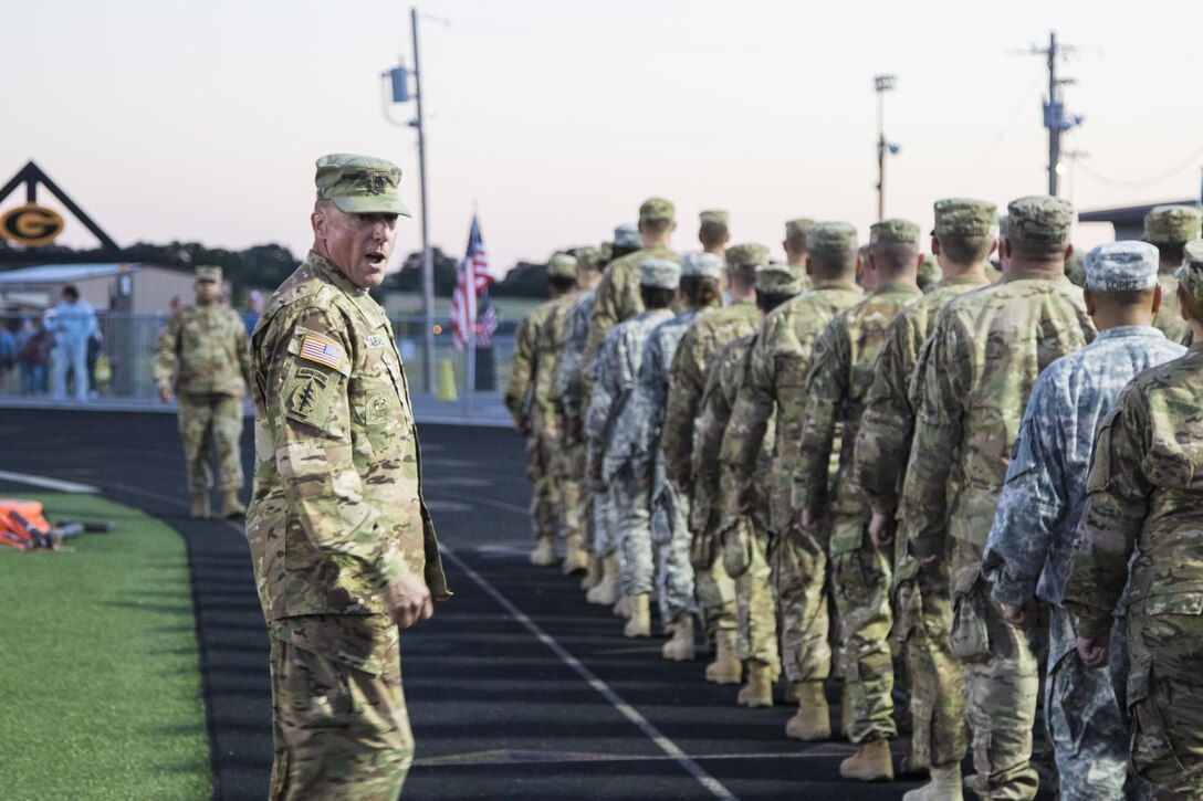 1st Sgt. Brian Jarvis, 316th Sustainment Command (Expeditionary) Headquarters and Headquarters Company 1st Sgt., marches Army Reserve Soldiers on to the Gatesville High School football field before a game in Gatesville, Tx., Oct. 21, 2016. (U.S. Army photo by Staff Sgt. Dalton Smith)
