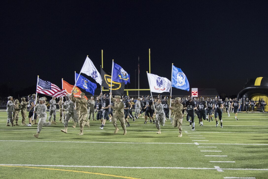 U.S. Army Reserve Soldiers run onto the Gatesville High School football field, while carrying the colors of every branch of the military, before a game in Gatesville, Tx., Oct. 21, 2016. (U.S. Army photo by Staff Sgt. Dalton Smith)