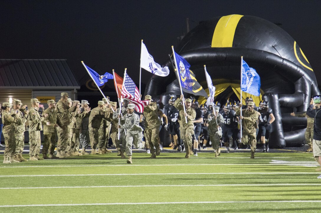 U.S. Army Reserve Soldiers run onto the Gatesville High School football field, while carrying the colors of every branch of the military, before a game in Gatesville, Tx., Oct. 21, 2016. (U.S. Army photo by Staff Sgt. Dalton Smith)