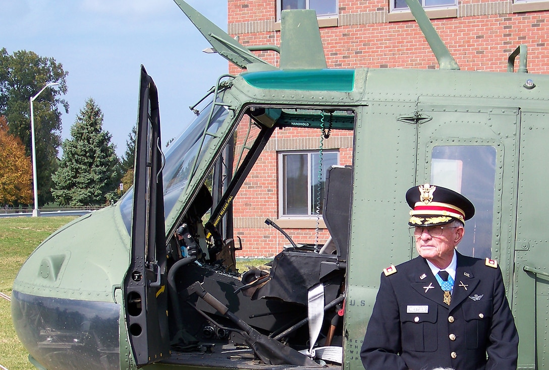 Army Lt. Col. Charles Kettles (Ret.) stands in front of a Vietnam-era helicopter on display at Defense Supply Center Columbus. Kettles was awarded the Medal of Honor July 18 for actions he performed as a pilot in Vietnam in a similar model aircraft. 