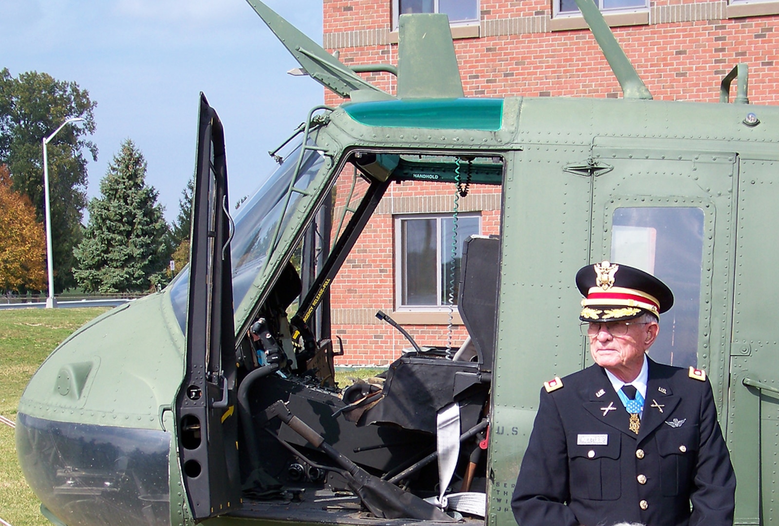 Army Lt. Col. Charles Kettles (Ret.) stands in front of a Vietnam-era helicopter on display at Defense Supply Center Columbus. Kettles was awarded the Medal of Honor July 18 for actions he performed as a pilot in Vietnam in a similar model aircraft. 