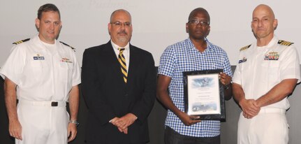 Saul Valle receives his certificate of achievement from Naval Surface Warfare Center Dahlgren Division (NSWCDD) Technical Director John Fiore, NSWCDD Commanding Officer Capt. Brian Durant, right, and Combat Direction Systems Activity Dam Neck Commanding Officer Cmdr. Andrew Hoffman at the 2016 NSWCDD academic awards ceremony. Valle was recognized for completing his doctorate in mechanical engineering from North Carolina State University, and commended for his commitment to personal and professional development.