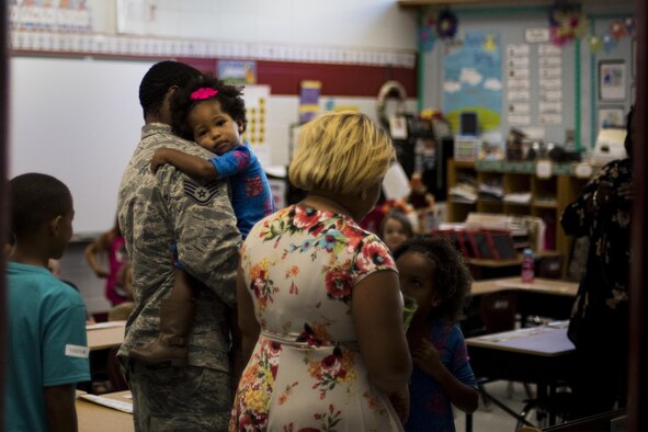 Staff Sgt. Justin Aiken, 822d Base Defense Squadron security forces member, holds his daughter after surprising his children at their school, Oct. 21, 2016, at Valdosta, Ga. Aiken had just returned from a deployment to Southwest Asia. (U.S. Air Force photo by Airman 1st Class Daniel Snider) 