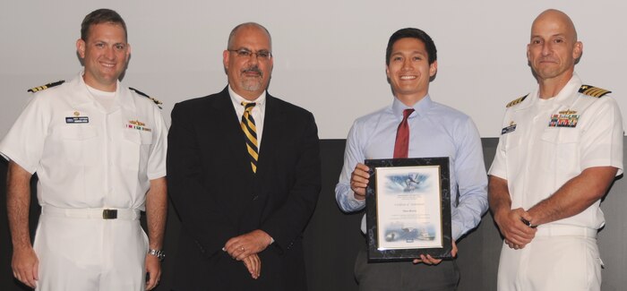 Marc Rivera receives his certificate of achievement from Naval Surface Warfare Center Dahlgren Division (NSWCDD) Technical Director John Fiore, NSWCDD Commanding Officer Capt. Brian Durant, right, and Combat Direction Systems Activity Dam Neck Commanding Officer Cmdr. Andrew Hoffman at the 2016 NSWCDD academic awards ceremony. Rivera was recognized for completing his master's degree in mechanical engineering from North Carolina State University, and commended for his commitment to personal and professional development. 