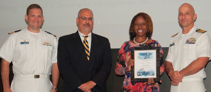 Shermeka Bolden receives her certificate of achievement from Naval Surface Warfare Center Dahlgren Division (NSWCDD) Technical Director John Fiore, NSWCDD Commanding Officer Capt. Brian Durant, right, and Combat Direction Systems Activity Dam Neck Commanding Officer Cmdr. Andrew Hoffman at the 2016 NSWCDD academic awards ceremony. Bolden was recognized for completing her master's degree in cybersecurity from the University of Maryland University College, and commended for her commitment to personal and professional development. 