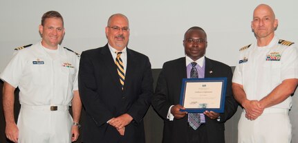 Eric Hirwa receives his certificate of appreciation from Naval Surface Warfare Center Dahlgren Division (NSWCDD) Technical Director John Fiore, NSWCDD Commanding Officer Capt. Brian Durant, right, and Combat Direction Systems Activity Dam Neck Commanding Officer Cmdr. Andrew Hoffman at the 2016 NSWCDD academic awards ceremony. Hirwa was recognized for completing his radar systems certification from Georgia Institute of Technology, and commended for his commitment to personal and professional development.