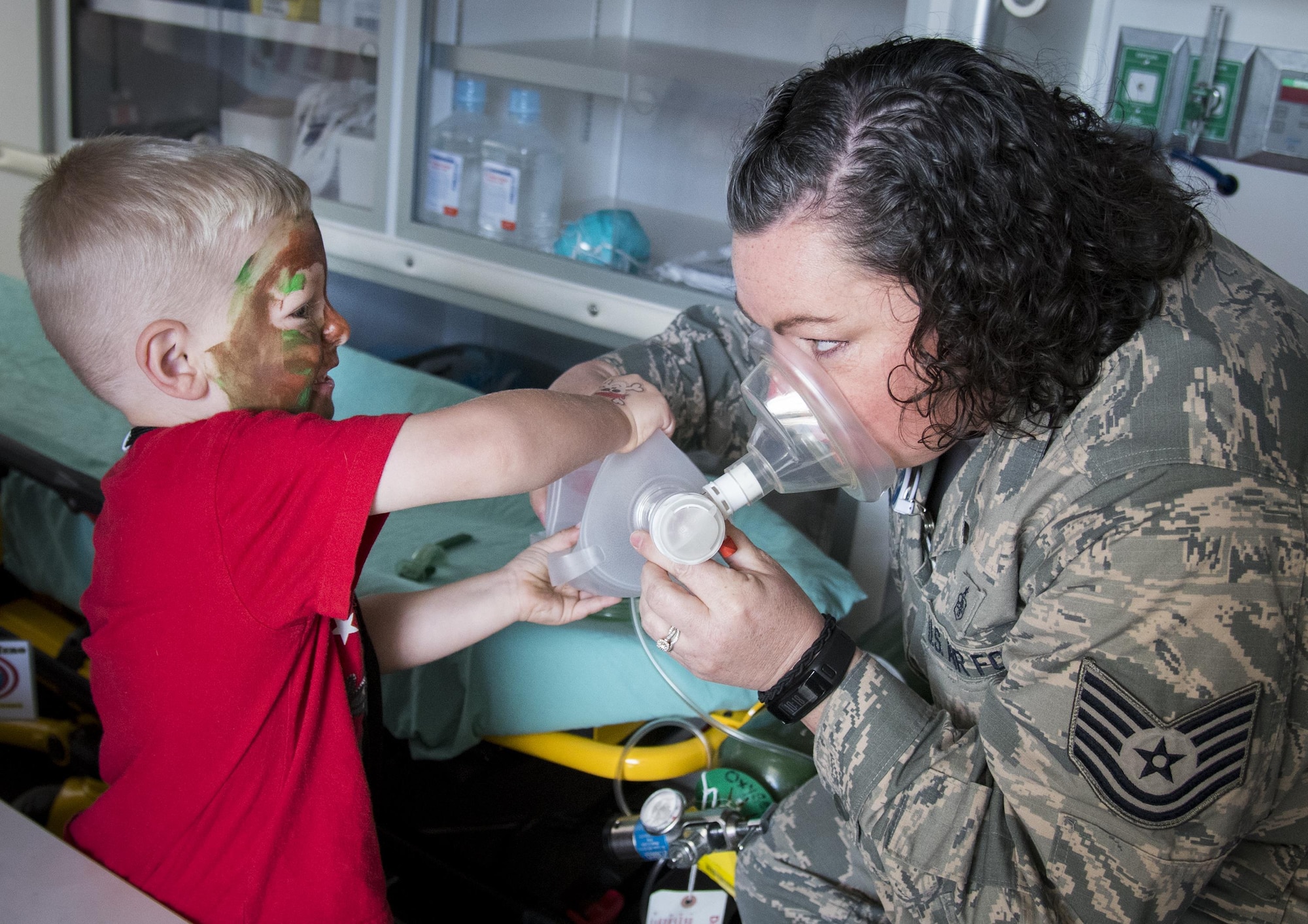 A new recruit helps an Airman with the oxygen pump at a medical display during the Operation Hero event Oct. 22 at Eglin Air Force Base, Fla.  More than 100 kids participated in the mock deployment experience created to give military children a glimpse of what their loved ones go through when they leave home. The kids went through a deployment line to get their dog tags and “immunizations” before they were briefed by the commander and shipped off to a deployed location. There, they participated in various activities and demonstrations by local base agencies. (U.S. Air Force photo/Samuel King Jr.)