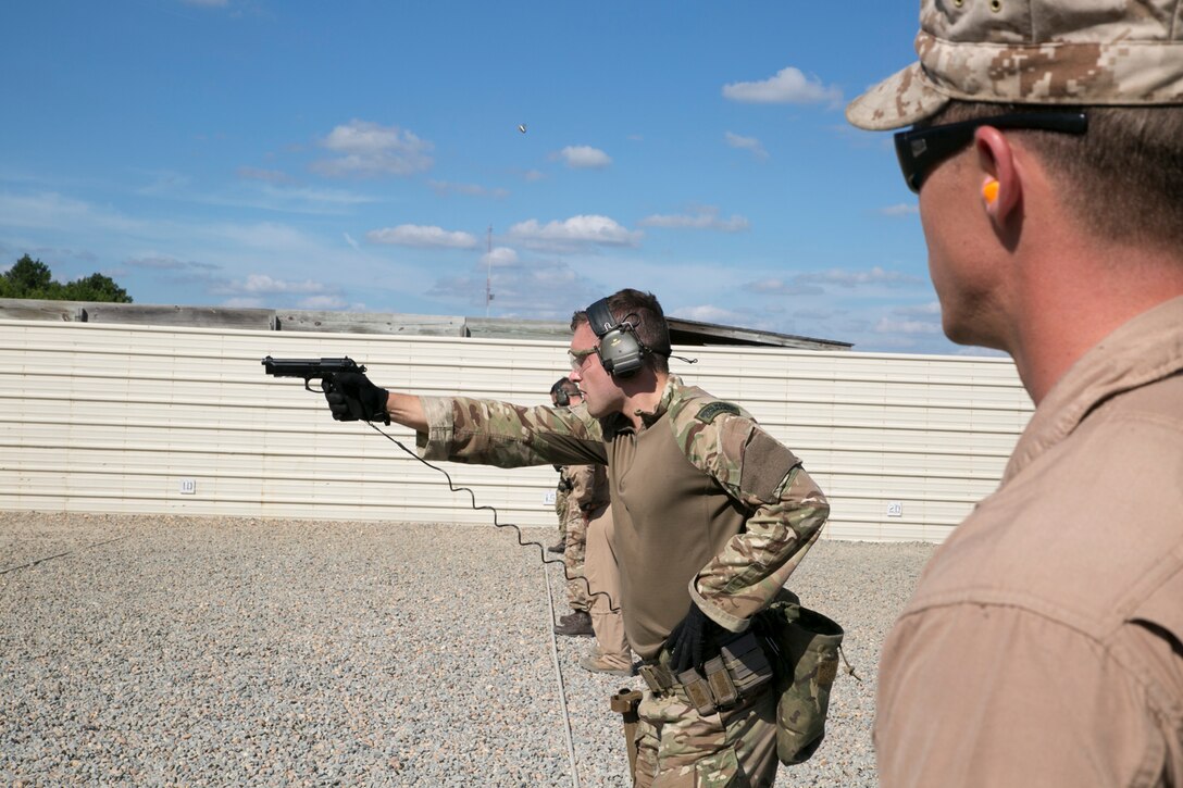 Royal Marine Lt. Ryan Taylor, recapture troop tactics officer-in-command, 43 Fleet Protection Group Royal Marines, fires his M9 Beretta service pistol at a team relay event during Exercise Tartan Eagle 16 Phase II, aboard Naval Support Activity Northwest Annex, Chesapeake, Va., Oct 20. Marines and sailors from Marine Corps Security Force Battalions Bangor, Wa., and Kings Bay, Ga., along with 43 FPGRM ended their day with a team-building exercise with members of each team sprinting to the firing line and firing one shot to knock down their targets. (Official Marine Corps photo by Sgt. Calvin Shamoon/Released)