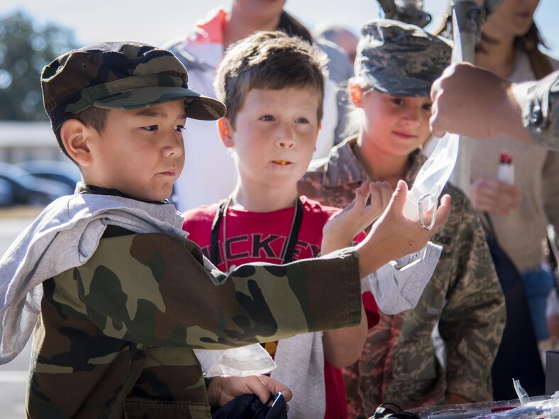 Three new recruits collect their supplies in the deployment line during the Operation Hero event Oct. 22 at Eglin Air Force Base, Fla.  More than 100 kids participated in the mock deployment experience created to give military children a glimpse of what their loved ones go through when they leave home. The kids went through a deployment line to get their dog tags and “immunizations” before they were briefed by the commander and shipped off to a deployed location. There, they participated in various activities and demonstrations by local base agencies. (U.S. Air Force photo/Samuel King Jr.)