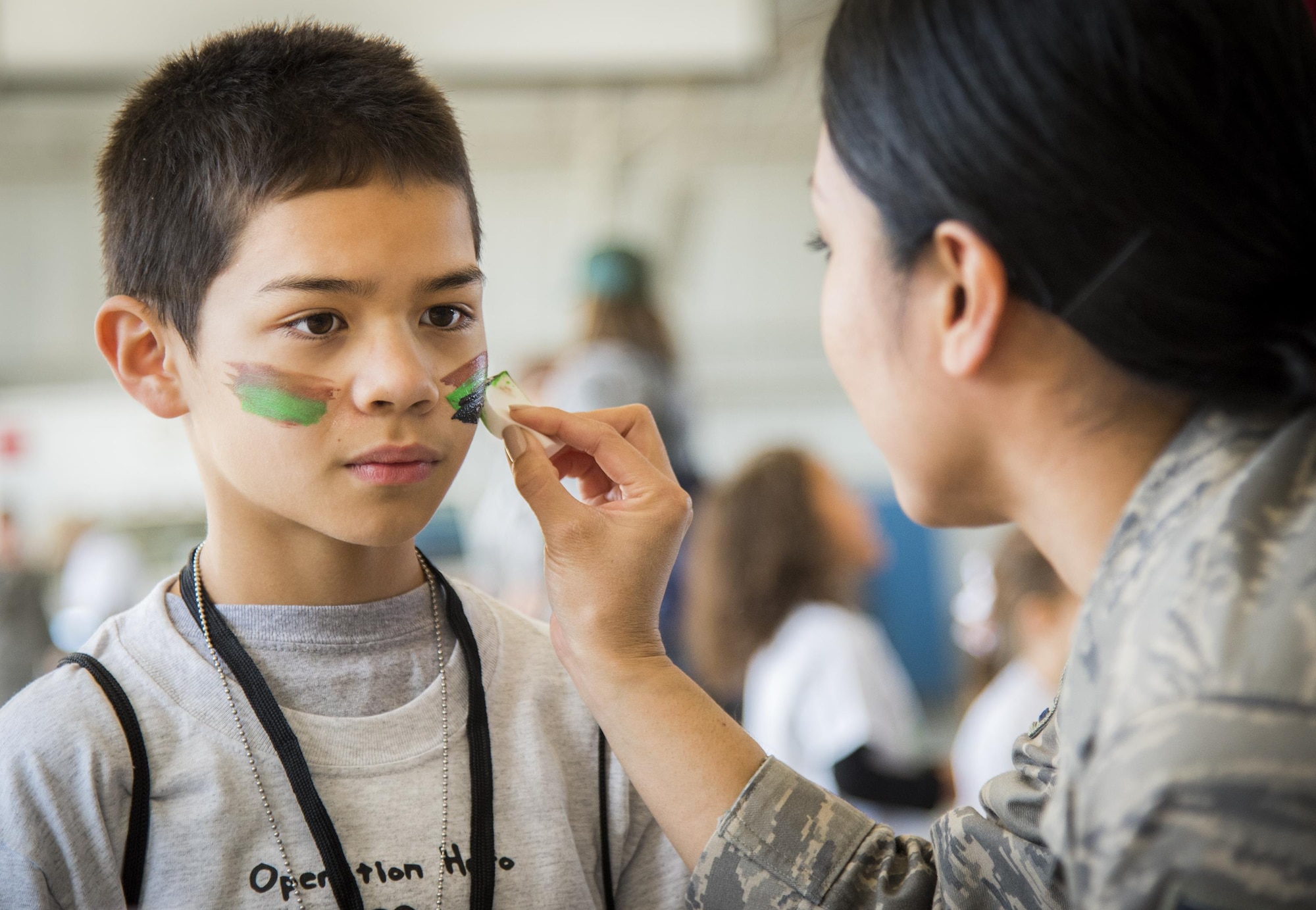 A new recruit gets his war paint applied during the Operation Hero event Oct. 22 at Eglin Air Force Base, Fla.  More than 100 kids participated in the mock deployment experience created to give military children a glimpse of what their loved ones go through when they leave home. The kids went through a deployment line to get their dog tags and “immunizations” before they were briefed by the commander and shipped off to a deployed location. There, they participated in various activities and demonstrations by local base agencies. (U.S. Air Force photo/Samuel King Jr.)