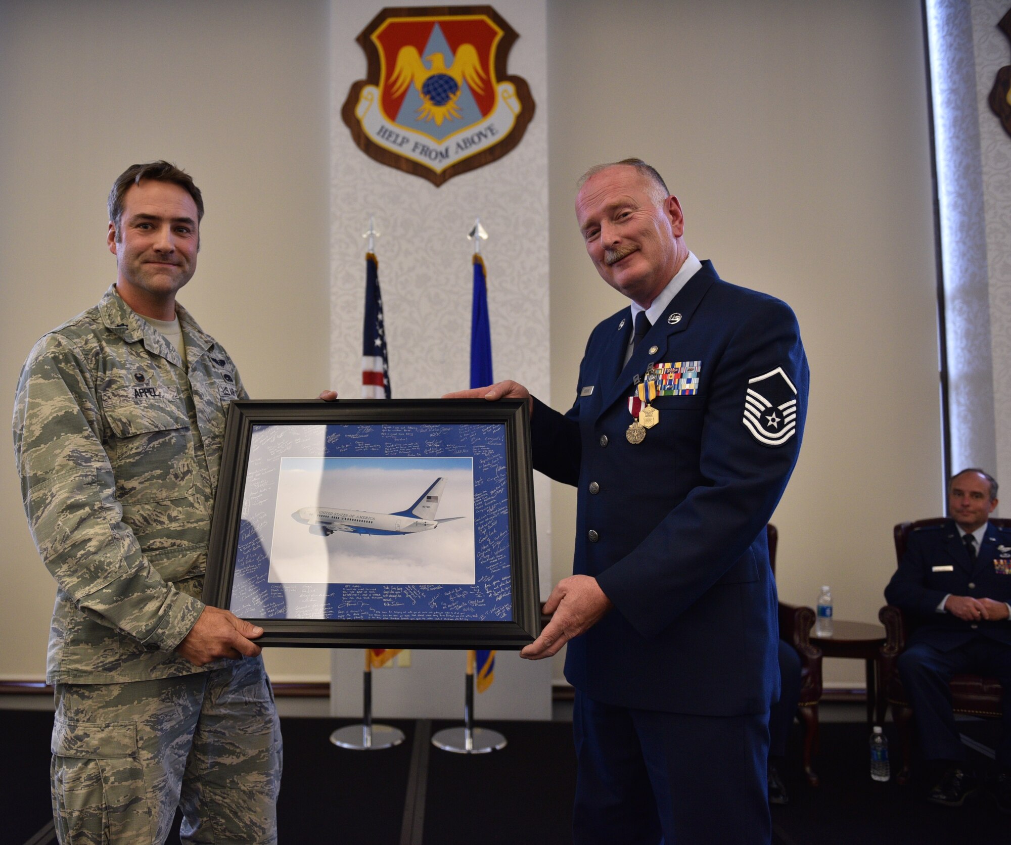 At right, retired Master Sgt. Gary Robbins stands with Lt. Col. Troy Appel, an officer and leader at the 932nd Maintenance Group, as he reads the autographs from fellow maintainers on a photo frame showing a flying C-40c aircraft he helped take care of at Scott Air Force Base, Illinois.  The honored tradition of a photo signed by coworkers was a token of gratitude for 33 years of service and a job well done.  (U.S. Air Force photo by Tech. Sgt. Christopher Parr)