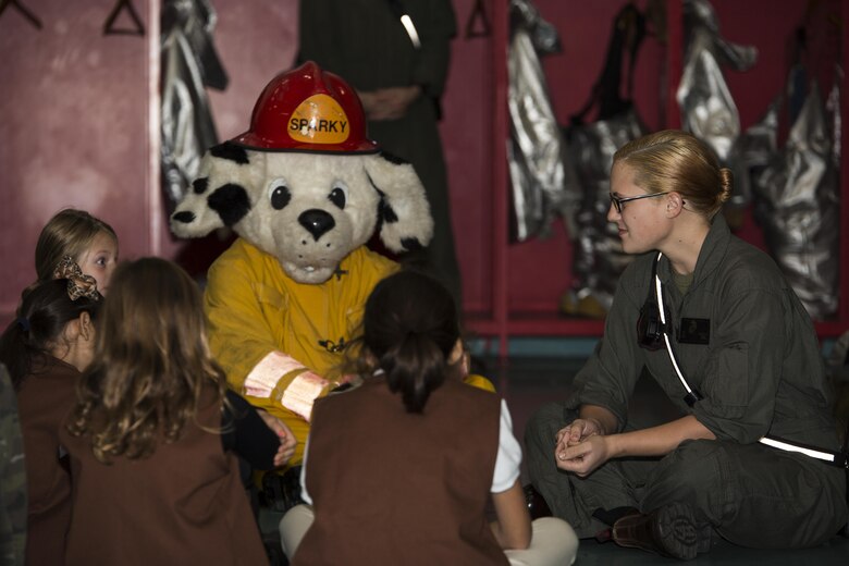 U.S. Marine Corps Lance Cpl. Allison Jenkins, firefighter specialist with Aircraft Rescue and Firefighting, and Sparky, the fire dog for Marine Corps Air Station Iwakuni, talk with Brownies of Iwakuni Brownies Troop 92 during a fire prevention and safety seminar at MCAS Iwakuni, Japan, Oct. 22, 2016. ARFF hosted the seminar to teach the girl scouts about the basics of fire safety, the actions to take when stuck in a fire, evacuation plans and how to effectively stop, drop and roll. (U.S. Marine Corps photo by Lance Cpl. Joseph Abrego)