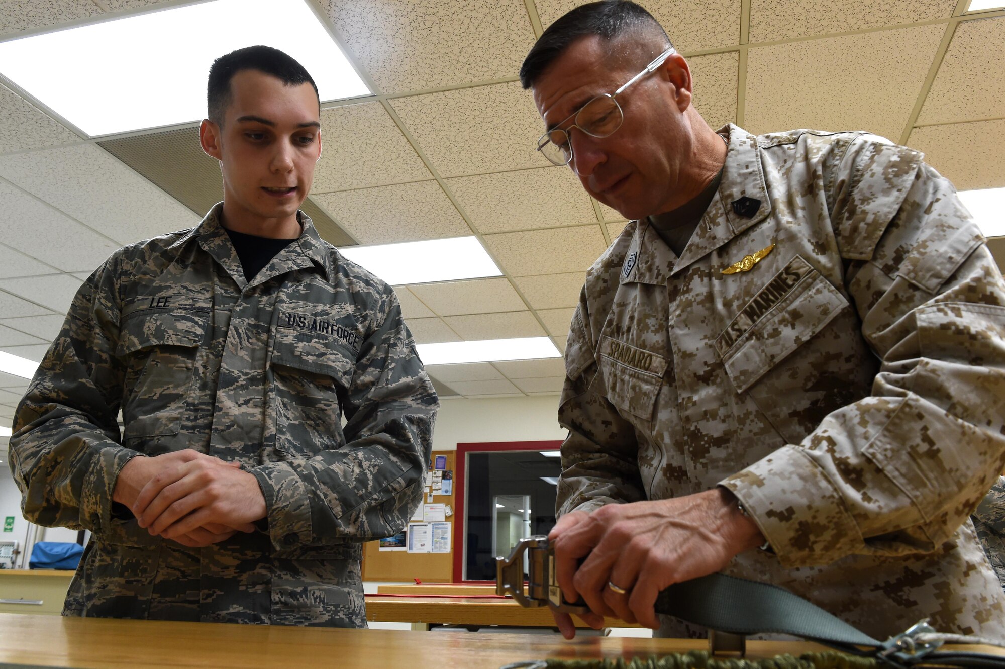 Airman 1st Class Dustin Lee, 3rd Operations Support Squadron aircrew flight equipment journeyman, explains the folding pattern of an F-22 Raptor parachute to Marine Corps Sgt. Maj. Anthony Spadaro, U.S. Pacific Command senior enlisted leader, at Joint Base Elmendorf-Richardson, Alaska, Oct. 21, 2016. Spadaro, a native of New Brunswick, New Jersey visited JBER for a three day immersion tour Oct. 19 to 21, 2016. Spadaro provides the PACOM commander with the enlisted perspective on theater security cooperation, encouraging peaceful development, responding to contingencies, and deterring aggression throughout the Indo-Asia-Pacific region. This was his first visit to Alaska. 