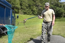 U.S. Air Force Senior Airman James Wheeler, 18th Civil Engineer Squadron pest management specialist, puts a Taiwanese Habu into a net Oct. 19, 2016, at Kadena Air Base, Japan.  The Taiwanese Habu is an invasive species to Okinawa and must be removed to protect the natural ecosystem. (U.S. Air Force photo by Airman 1st Class Corey M. Pettis)
