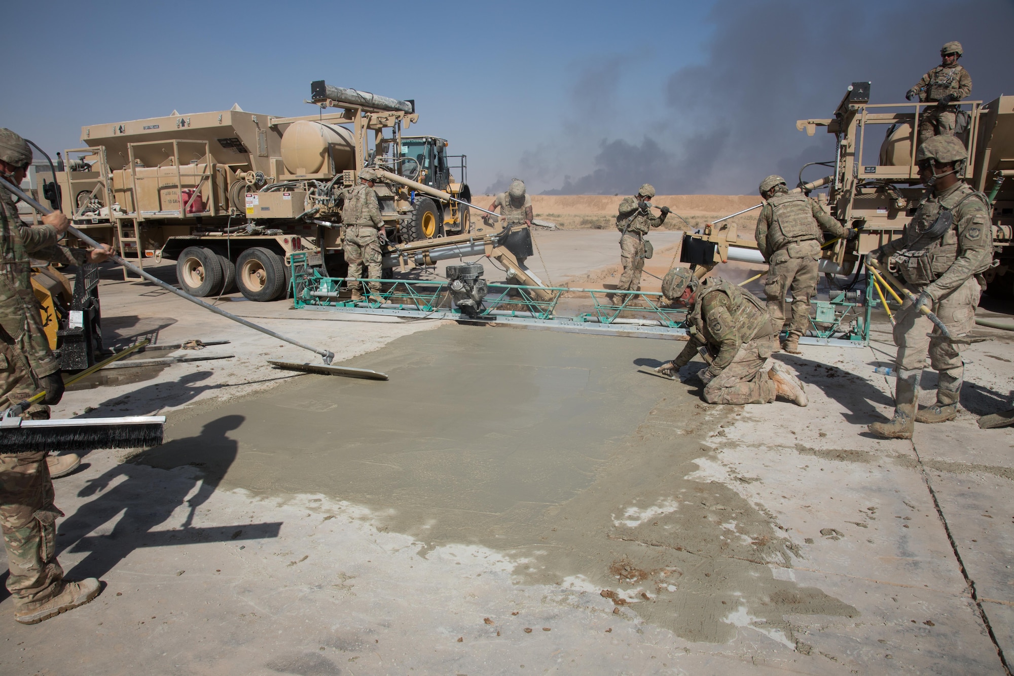 U.S. Airmen assigned to the 1st Expeditionary Civil Engineer Group fill trenches with concrete during runway repair operations at Qayyarah West Airfield, Iraq, Oct. 9, 2016. The Islamic State of Iraq and the Levant (ISIL) destroyed the runway by using heavy machinery and explosives to disrupt coalition forces from gaining control in the area. A Coalition of regional and international nations have joined together to enable Iraqi forces to counter ISIL, reestablish Iraq’s borders and re-take lost terrain thereby restoring regional stability and security.  (U.S. Army photo by Spc. Christopher Brecht)