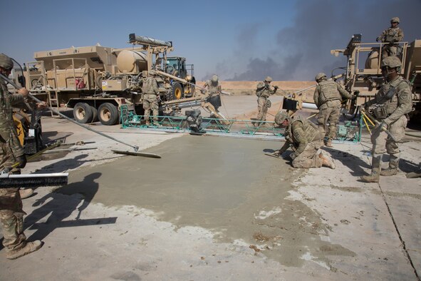 U.S. Airmen assigned to the 1st Expeditionary Civil Engineer Group fill trenches with concrete during runway repair operations at Qayyarah West Airfield, Iraq, Oct. 9, 2016. The Islamic State of Iraq and the Levant (ISIL) destroyed the runway by using heavy machinery and explosives to disrupt coalition forces from gaining control in the area. A Coalition of regional and international nations have joined together to enable Iraqi forces to counter ISIL, reestablish Iraq’s borders and re-take lost terrain thereby restoring regional stability and security.  (U.S. Army photo by Spc. Christopher Brecht)