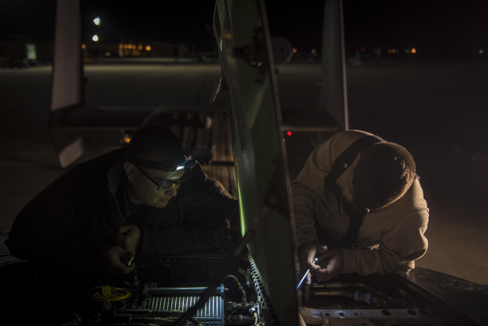 Civilian and active duty crew chiefs with the 20th Aircraft Maintenance Unit, 727th Special Operations Aircraft Maintenance Squadron work together to carefully extract a damaged part from a CV-22 Osprey Oct. 18, 2016 at Cannon Air Force Base, N.M. The 20th Aircraft Maintenance Unit is one of many shops at Cannon that operates 24 hours a day, keeping the 27th Special Operations Wing ready, relevant and resilient any time, any place. (U.S. Air Force Photo by Senior Airman Shelby Kay-Fantozzi/released)