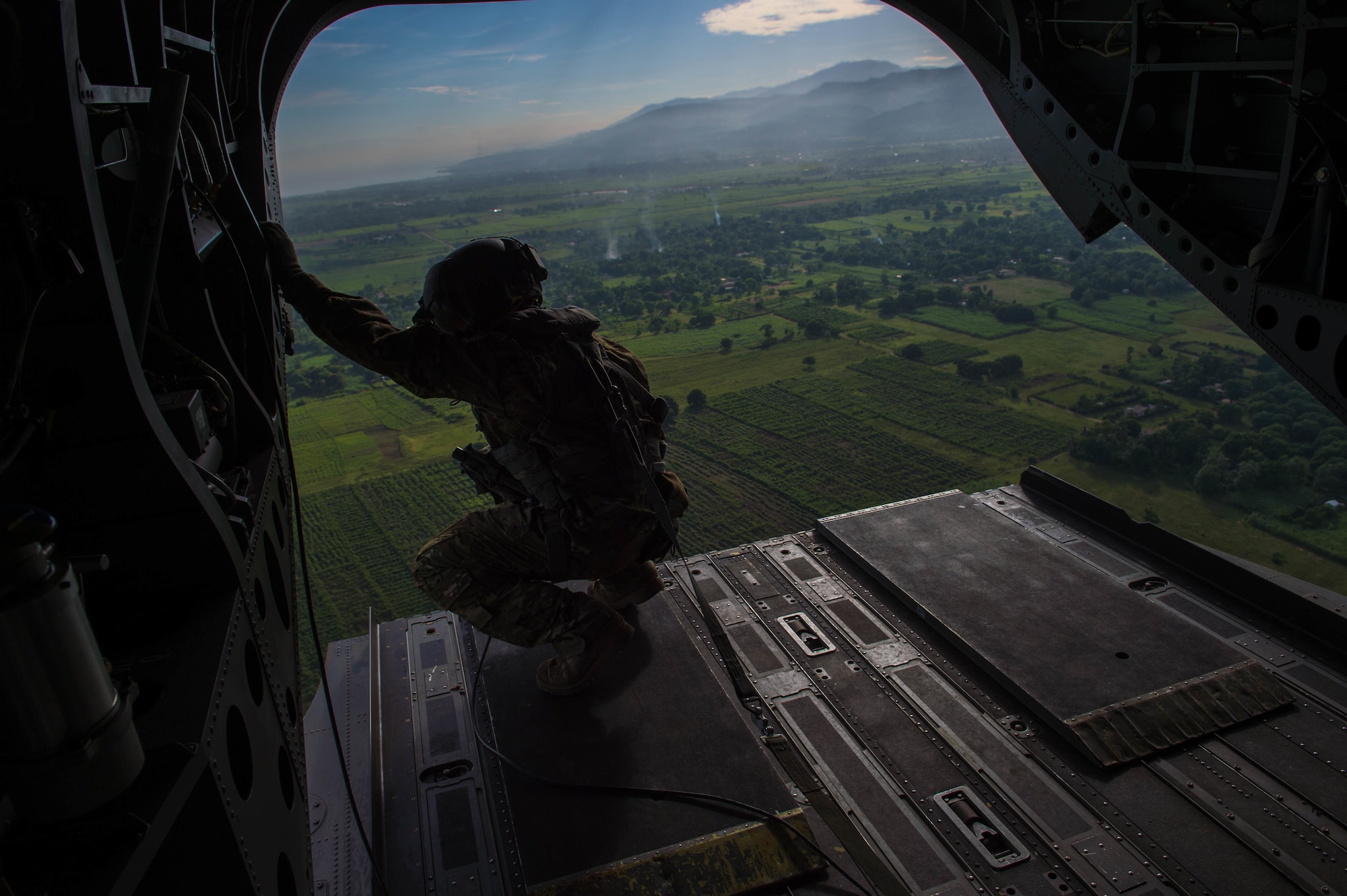 U.S. Army Staff Sgt. Jim Burley, 1st battalion-228th aviation regiment flight engineer, looks out the back of a U.S. Army CH-47 Chinook during an aid relief mission Oct. 14, 2016 in Port-au-Prince, Haiti. JTF Matthew was a U.S. Southern Command lead humanitarian assistance, disaster relief effort in Haiti following Hurricane Matthew. Matthew was a category 4 hurricane that formed in the Western Atlantic Ocean and affected Haiti, eastern Cuba, and the Bahamas before moving up the southeast coast of the United States. (U.S. Air Force photo by Staff Sgt. Paul Labbe)