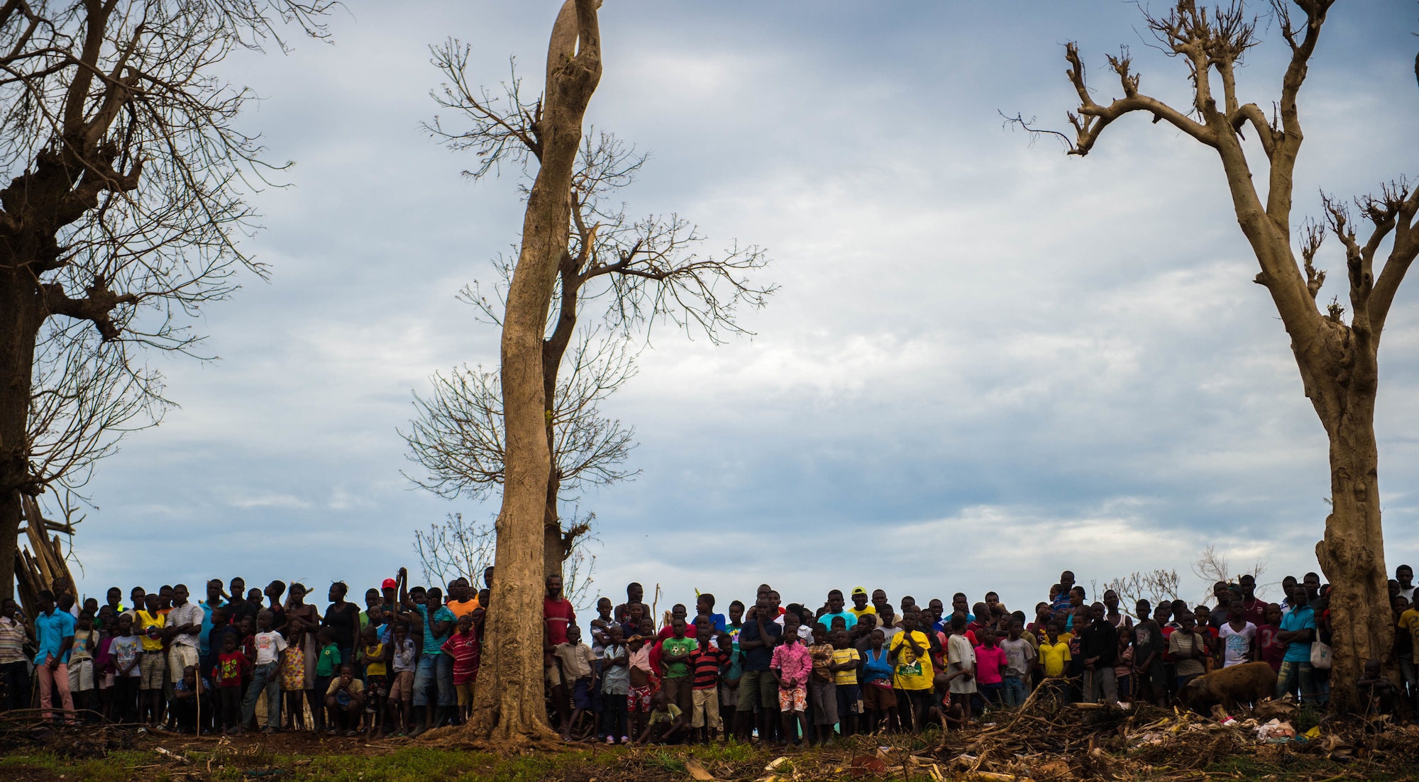 A group of Haitian villagers stand on a hilltop while U.S. service members transport aid to them during an aid relief mission Oct. 14, 2016 in Anse d'Hainault, Haiti. JTF Matthew was a U.S. Southern Command lead humanitarian assistance, disaster relief effort in Haiti following Hurricane Matthew. Matthew was a category 4 hurricane that formed in the Western Atlantic Ocean and affected Haiti, eastern Cuba, and the Bahamas before moving up the southeast coast of the United States. (U.S. Air Force photo by Staff Sgt. Paul Labbe)