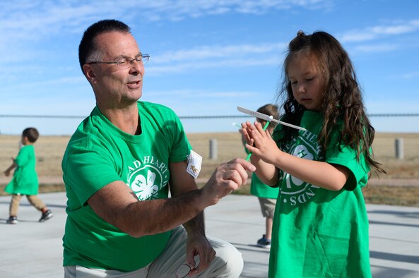 Jim Szczur, Missile Defense Agency project engineer, helps Zoey Nerey-Shaffer learn how to fly a “whirley-gig” during 4-H National Youth Science Day at Schriever Air Force Base, Colorado, Friday, Oct. 21, 2016. Schriever School Age Care program youth learned about flight through experiments with the “whirley-gigs” and other forms of aircraft. (U.S. Air Force photo/Christopher DeWitt)