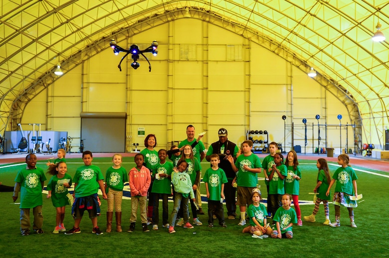 Schriever School Age Care program members watch a drone fly through the indoor running track at Schriever Air Force Base, Colorado, during 4-H National Youth Science Day Friday, Oct. 21, 2016. 4-H NYSD was created to drive interest in science, technology, engineering and mathematics-related career fields by having kids around the world perform the same experiments at the same time. This year’s experiments focused on flight. (U.S. Air Force photo/Christopher DeWitt)