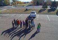 Schriever School Age Care program members point at a drone in flight during a flight lesson at Schriever Air Force Base, Colorado, Wednesday, Oct. 19, 2016. Youth spent Oct. 17-21 learning about the science and theories behind flight in preparation for 4-H National Youth Science Day. (Courtesy photo)