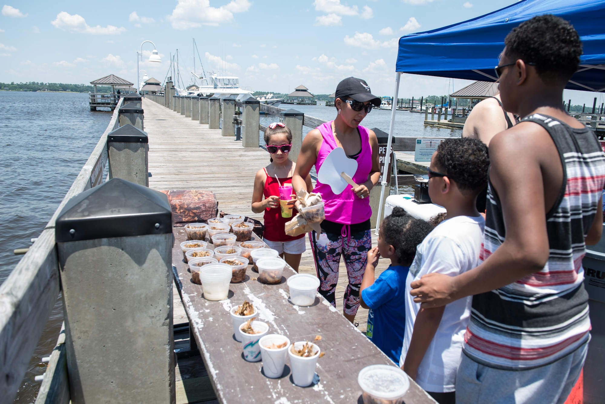 Families gather fishing supplies for the kids’ fishing rodeo during the Celebration of Our Nation event at Marina Park July 2, 2016, on Keesler Air Force Base, Miss. The event also included a golf scramble, mullet toss, fireworks display and music performances. (U.S. Air Force photo by Marie Floyd/Released)