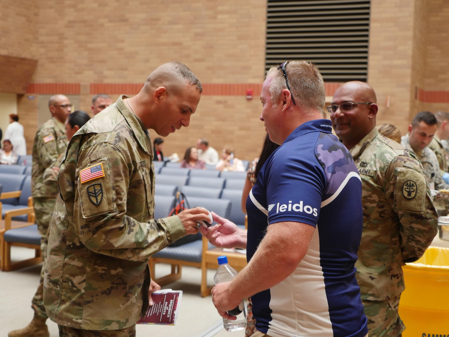 Brooke Army Medical Center Command Sgt. Maj. Albert Crews (left) inspects a miniature souvenir Rugby ball The British Army Medical Services Rugby Team was giving to patrons during their Oct. 14 visit. The team attended the Hispanic Heritage Day ceremony in the medical mall and toured the Center for the Intrepid.