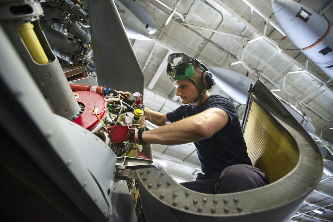 Navy Petty Officer 1st Class Hunter MacLelland inspects the engine of an MH-60S Seahawk helicopter in the hangar bay of the aircraft carrier USS Dwight D. Eisenhower in the Persian Gulf, Oct. 20, 2016. MacLelland is an aviation machinist's mate. The helicopter is assigned to Helicopter Sea Combat Squadron 7. Navy photo by Petty Officer 3rd Class Andrew J. Sneeringer