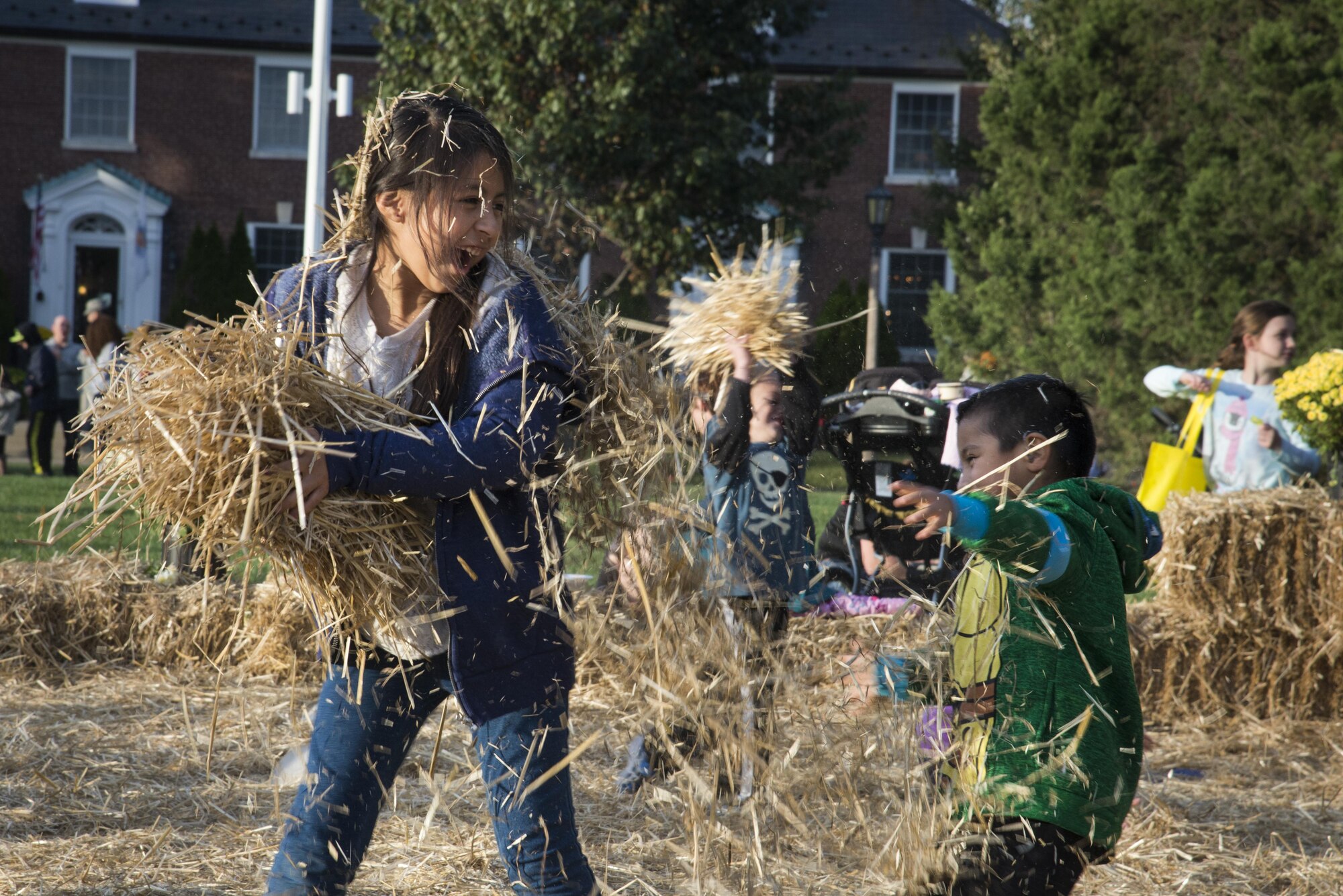 Children have a hay fight during the Fall Fest October 21, 2016 at Scott Air Force Base, Illinois. The Festival offered a pumkin patch where children could pick out pumpkins. (U.S. Air Force photo by Airman 1st Class Gwendalyn Smith)