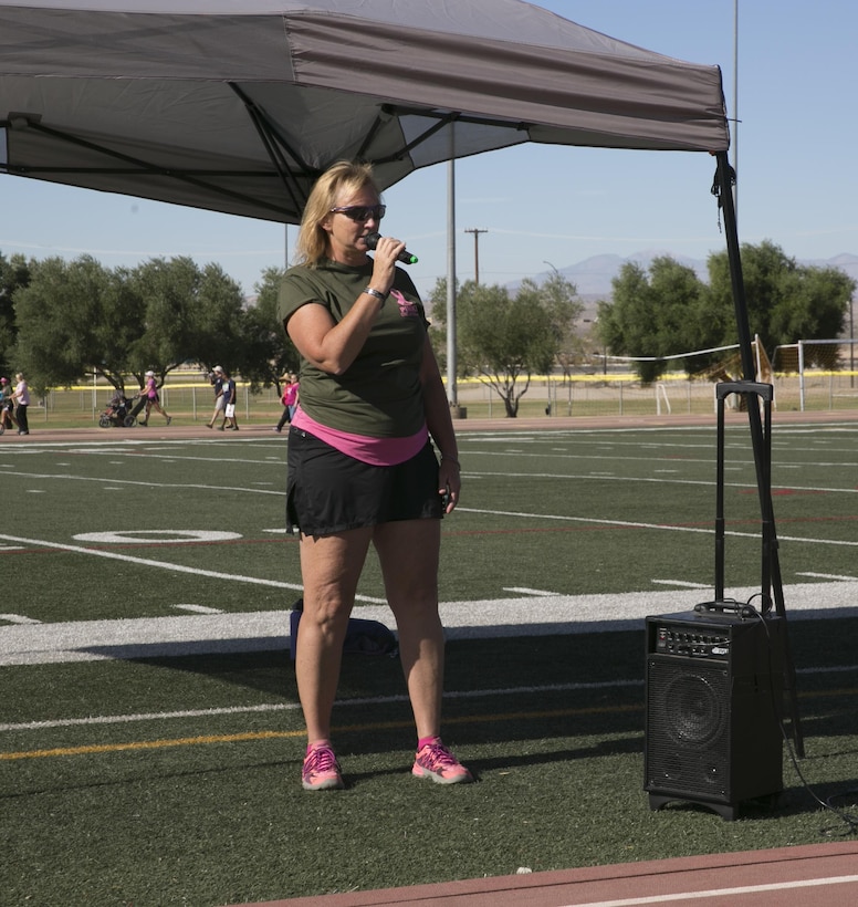 Diane Durden, family readiness officer, 2nd Battalion, 7th Marine Regiment, speaks to participants of the Officers' Spouses' Club’s third annual Pink Breast Cancer Awareness Walk about her fight with breast cancer at Felix Field aboard the Marine Corps Air Ground Combat Center, Twentynine Palms, Calif., Oct. 14, 2016. OSC hosted the walk to raise awareness and money for breast cancer research. (Official Marine Corps photo by Lance Cpl. Dave Flores/Released)