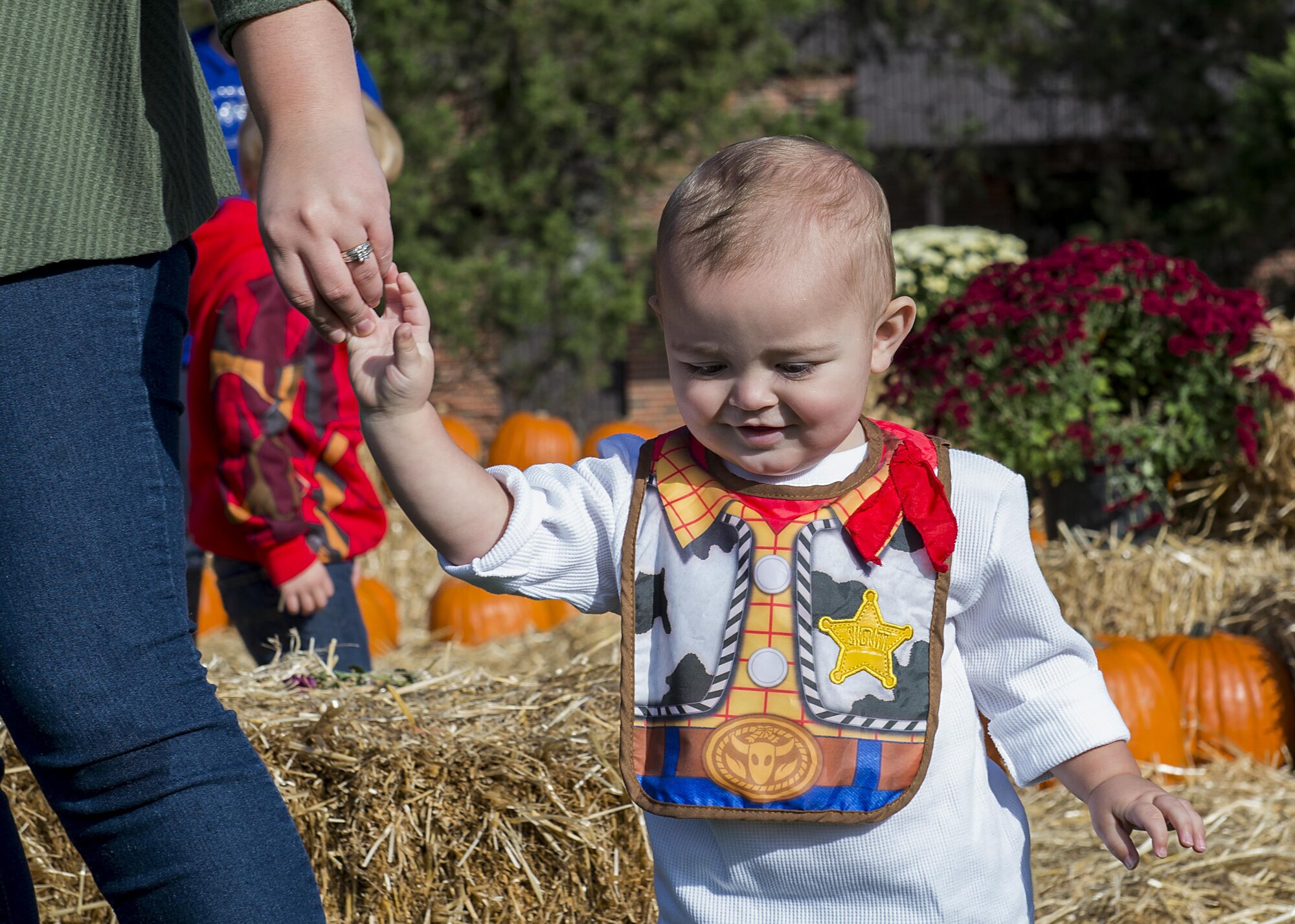 A child holds his mother's hand outside the pumpkin patch at the second annual Harvest Festival at Scott Air Force Base, Ill. on Oct. 21, 2016. The Harvest Festival had 400 pumpkinss for Scott Airmen and their families to pick from. (U.S. Air Force Photo by Senior Airman Megan Friedl)